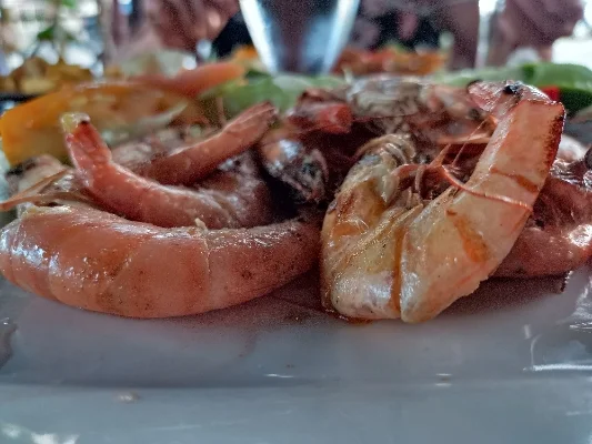 Plato con camarones frescos y verduras servido en un restaurante local.
