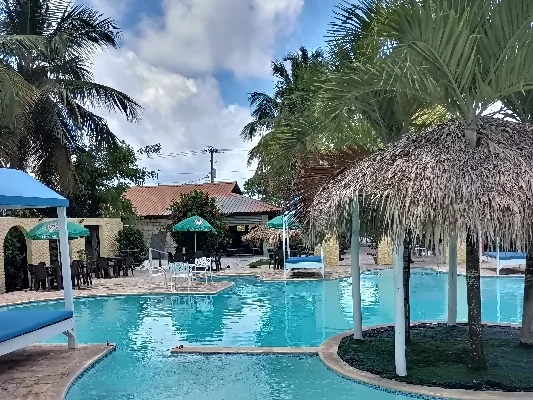 Piscina del restaurante El Currican en Juan Dolio rodeada de palmeras.